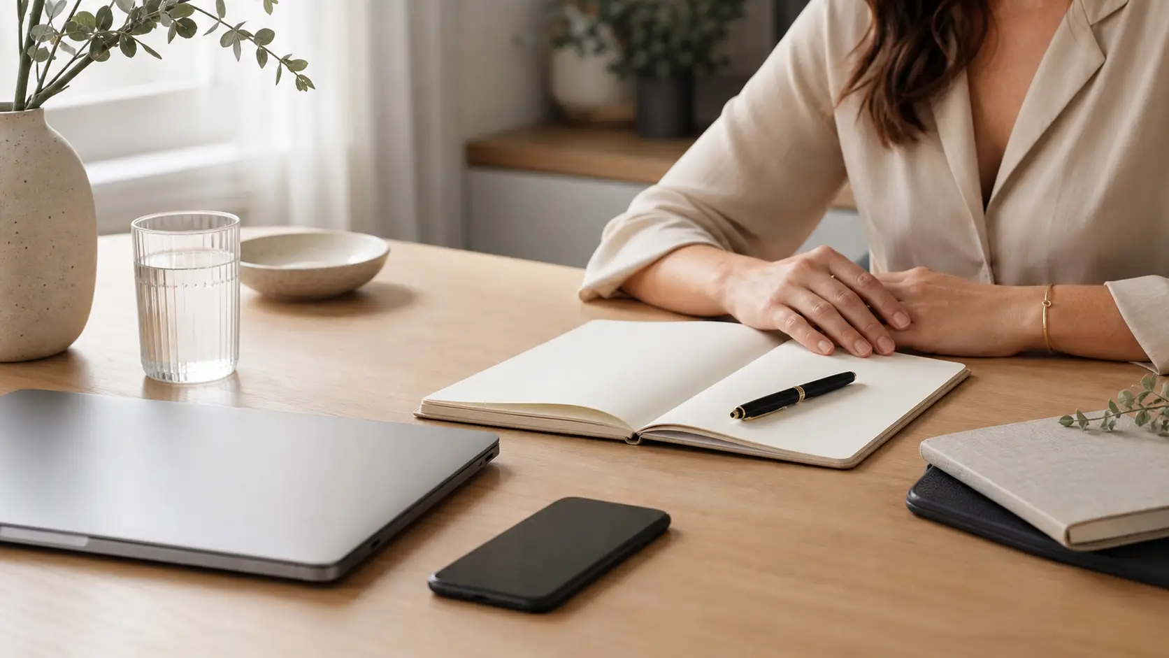 Calm workspace with journal and phone face down for stress management for leaders